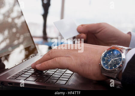 Unternehmer ist auf einem Laptop mit einer Holding-Kreditkarte einkaufen. Stockfoto
