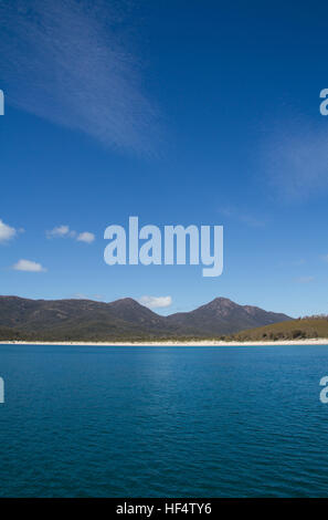 Blick auf die Wine Glass Bay mit Bergen, blauem Meer und blauem Himmel Stockfoto