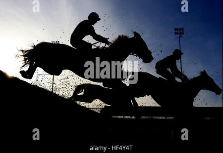 Läufer löschen einen frühen Zaun während 32Red.com Steeple Chase Rennen laufen während der Tag eines der 32Red Winterfestival in Kempton Park Racecourse. Stockfoto