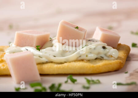 Dünne knusprige Cracker mit Frischkäse, Schinken und Petersilie Stockfoto