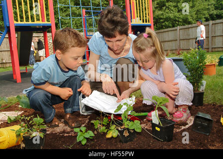 Nur lernen Baumschule mit Manager Julie preece und Kinder Mohn gadd (4) und William cryer (4), Garten auf dem Spielplatz. Stockfoto