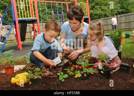 Nur lernen Baumschule mit Manager Julie preece und Kinder Mohn gadd (4) und William cryer (4), Garten auf dem Spielplatz. Stockfoto