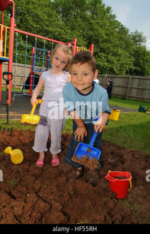 Nur lernen Baumschule mit Manager Julie preece und Kinder Mohn gadd (4) und William cryer (4), Garten auf dem Spielplatz. Stockfoto