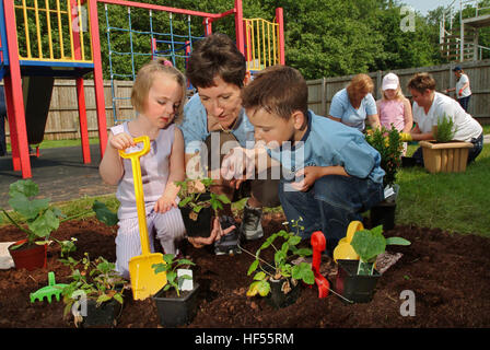 Nur lernen Baumschule mit Manager Julie preece und Kinder Mohn gadd (4) und William cryer (4), Garten auf dem Spielplatz. Stockfoto