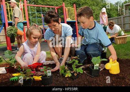 Nur lernen Baumschule mit Manager Julie preece und Kinder Mohn gadd (4) und William cryer (4), Garten auf dem Spielplatz. Stockfoto