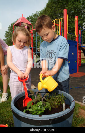 Nur lernen Baumschule mit Manager Julie preece und Kinder Mohn gadd (4) und William cryer (4), Garten auf dem Spielplatz. Stockfoto