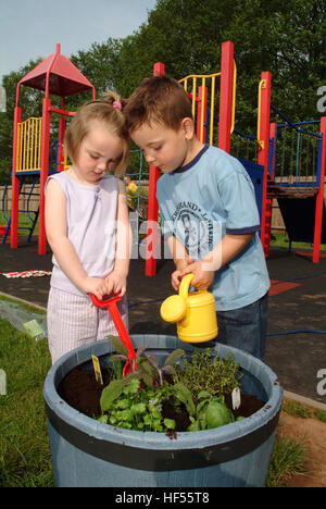 Nur lernen Baumschule mit Manager Julie preece und Kinder Mohn gadd (4) und William cryer (4), Garten auf dem Spielplatz. Stockfoto