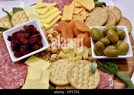 Ein Teller Essen vorbereiten für eine Weihnachtsfeier, bestehend aus Käse, Cracker, getrockneten Früchten, Nüssen und Oliven als Vorspeise Stockfoto