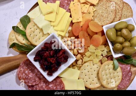 Ein Teller Essen vorbereiten für eine Weihnachtsfeier, bestehend aus Käse, Cracker, getrockneten Früchten, Nüssen und Oliven als Vorspeise Stockfoto