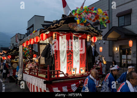 Menschen ziehen eine mobile Bühne für Tänzer, während ein Sommerfest in Shiozawa, Japan. Stockfoto