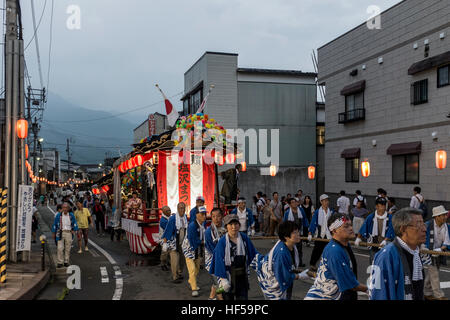 Menschen ziehen eine mobile Bühne für Tänzer, während ein Sommerfest in Shiozawa, Japan. Stockfoto