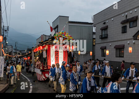 Menschen ziehen eine mobile Bühne für Tänzer, während ein Sommerfest in Shiozawa, Japan. Stockfoto