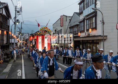 Menschen ziehen eine mobile Bühne für Tänzer, während ein Sommerfest in Shiozawa, Japan. Stockfoto