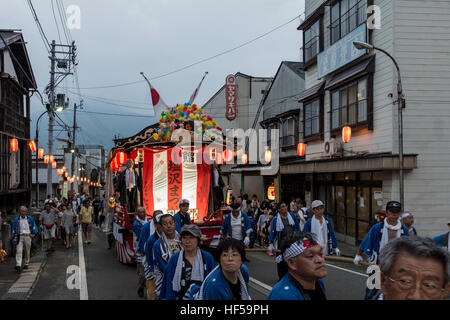 Menschen ziehen eine mobile Bühne für Tänzer, während ein Sommerfest in Shiozawa, Japan. Stockfoto