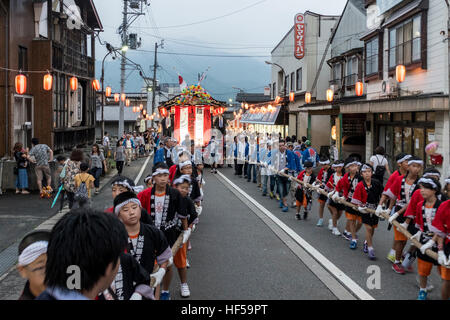 Menschen ziehen eine mobile Bühne für Tänzer, während ein Sommerfest in Shiozawa, Japan. Stockfoto