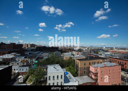 Geschwollene weiße Wolken über einem Brooklyn Nachbarschaft Stockfoto