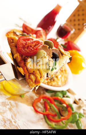 Stück Pizza mit Thunfisch, Oliven, Champignons und Tomaten Stockfoto