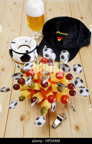 Käse-Snacks, Fingerfood, Fußball Fahnen, Fußball Fanartikel, Aschenbecher, Fußball Kappe, Pfeife und ein Glas Bier Stockfoto