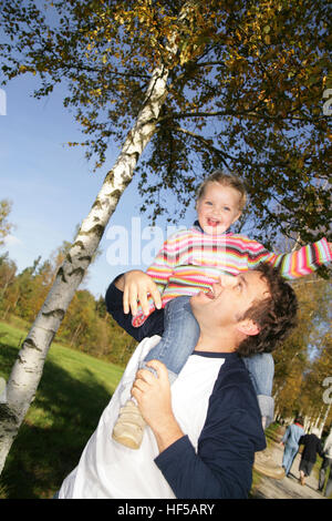 Vater geben seine drei-jährige Tochter eine Huckepack Fahrt Stockfoto