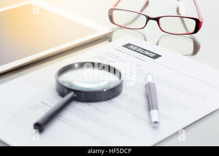 Geschäftsmann oder Arbeitsuchende überprüfen Sie seinen Lebenslauf auf seinem Schreibtisch vor dem Senden auf der Suche nach einem neuen Job mit Stift, Krawatte, Gläser und digital-Tablette. Stockfoto