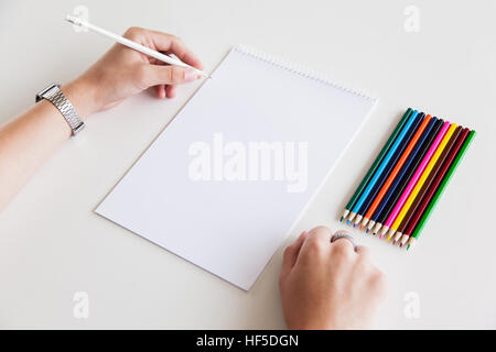 Mannes Hand mit Bleistift vor leerem Papier auf weißem Hintergrund. Mock-up-Branding. Stockfoto