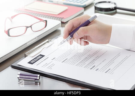 Geschäftsmann oder Arbeitsuchende überprüfen Sie seinen Lebenslauf auf seinem Schreibtisch vor dem Senden auf der Suche nach einem neuen Job mit Stift, Krawatte, Gläser und digital-Tablette. Stockfoto