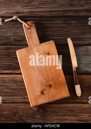 Schneidebrett und Messer auf dem Holztisch Stockfoto