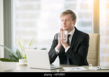 Geschäftsmann in Yoga-Pose am Schreibtisch Stockfoto