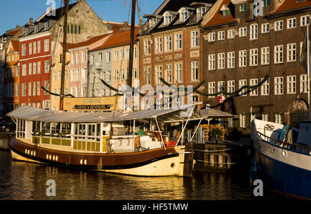 Dänemark, Kopenhagen, Nyhavn, Boote neben Kai Lagerhallen umgewandelt zu Wohnraum und Restaurants im frühen Morgenlicht Stockfoto