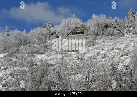 Haus am Berggipfel im Schnee Stockfoto