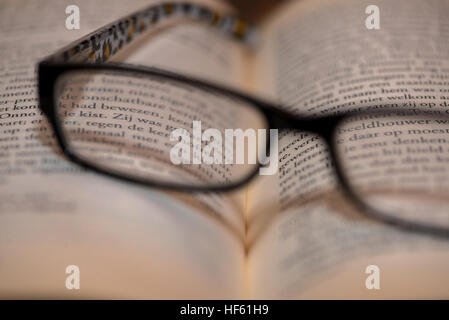 Brille auf offenes Buch Stockfoto