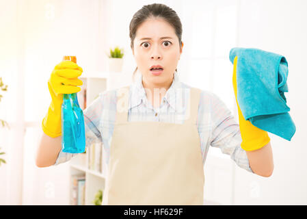 schockiert Hausfrau Reinigung Arbeiter bereit für Fenster mit Gummihandschuhen und Lappen reinigen. Ziemlich lächelnde junge Mischlinge Asiatin Stockfoto