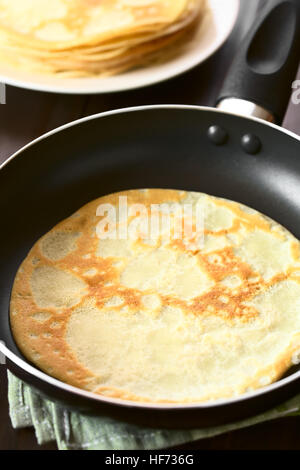 Frisch zubereitete Crepe in Pfanne mit einem Stapel von Pfannkuchen in den Rücken, fotografiert mit natürlichem Licht (Tiefenschärfe) Stockfoto