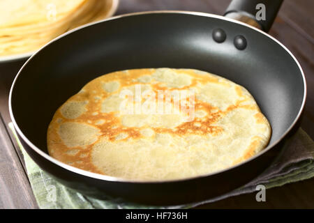 Frisch zubereitete Crepe in Pfanne mit einem Stapel von Pfannkuchen in den Rücken, fotografiert mit natürlichem Licht (Tiefenschärfe) Stockfoto