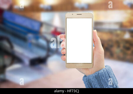 Smartphone-Modell. Frau mit mobilen mit weißen isoliert Display für die Präsentation. Einkaufszentrum im Hintergrund. Stockfoto