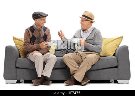 Senioren, die auf dem Sofa sitzen und reden auf weißem Hintergrund isoliert Stockfoto