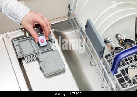 Hand des Mannes Tablet im Geschirrspüler Waschmittel Box setzen Stockfoto