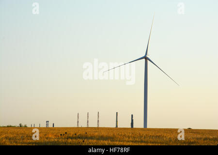 Windenergieanlagen, die Spinnen auf landwirtschaftlichen Bereich an einem Sommertag Stockfoto