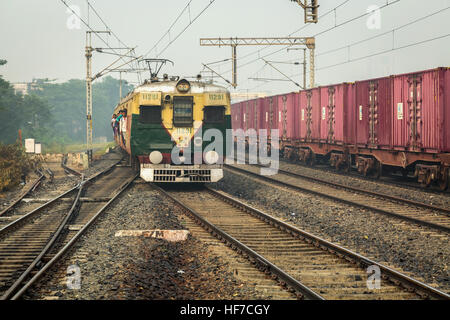 Überfüllten lokaler Personenzug der indischen Eisenbahnen eine Bahn-Bahnsteig an einem nebligen Wintermorgen zu betreten. Stockfoto