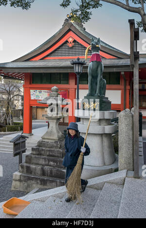 Frau geschwungene Treppe neben Kitsune (Fuchs) Statue mit Reis Stengel, Gai-Haiden, Fushimi Inari-Taisha-Shinto-Schrein, Kyoto, Japan Stockfoto