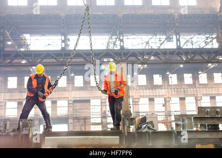 Stahlarbeiter mit Kranhaken in Fabrik Stockfoto