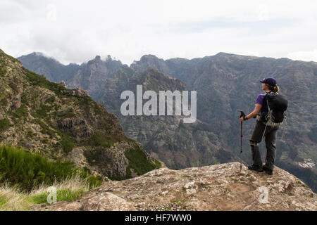 Eine einsame weibliche Wanderer mit Blick auf den Kämmen des Pico Do Arieiro in den Bergen von Madeira. Stockfoto