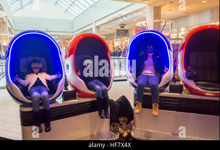 Besucher der Queens Center Mall im Stadtteil Queens in New York OnSaturday, 17. Dezember 2016 virtual-Reality-Brille tragen und sitzen in Schoten rockt, wie sie ein virtual-Reality-Video ansehen.  (© Richard B. Levine) Stockfoto