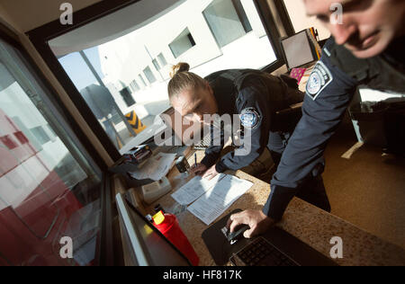 U.S. Customs and Border Protection Offiziere überprüfen Sie die Anmeldeinformationen des LKW-Fahrer und seine Sendung als er die US-Prüfpunkt der Cargo-Pre-Inspection bei Otay Mesa, Kalifornien, Zollhafen, 23. Juni 2016 durchläuft. An einem bestimmten Tag Line-up mehrere hundert LKWs auf der mexikanischen Seite der Grenze, importierte Produkte warten auf den Prozess des Screenings von Zollbeamten zu liefern. Eine wachsende Zahl von Reedereien sind CBPs Cargo Pre-Inspection zunutze, die vertrauenswürdigen Versendern schnellere und effizientere Mittel zur Lieferung der Produkte an US-Einzelhändler ermöglicht.  von Glenn Fawcett Stockfoto