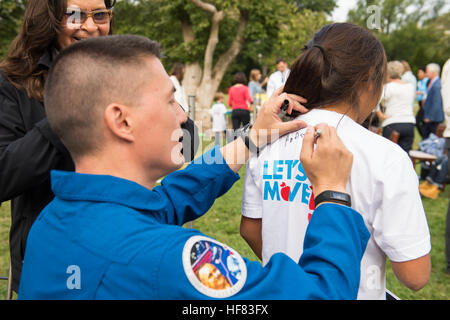 NASA-Astronaut Kjell Lindgren unterschreibt die Rückseite eines Schülers Hemdes mit dem lateinischen Ausdruck "Ad Astra", was bedeutet "zu den Sternen", nach der Ernte der White House Küchengarten mit First Lady Michelle Obama und anderen Gästen auf Donnerstag, 6. Oktober 2016 in Washington. Im Frühjahr trat NASA Beamte die First Lady in Pflanzen Samen in den Garten, einschließlich Sämlinge derselben Sorte von Salat, die als Bestandteil der Veggie-Experiment auf der internationalen Raumstation angebaut wurden. Lindgren geerntet die ursprüngliche Ernte von Salat an Bord der Raumstation während seiner Zeit auf Stockfoto