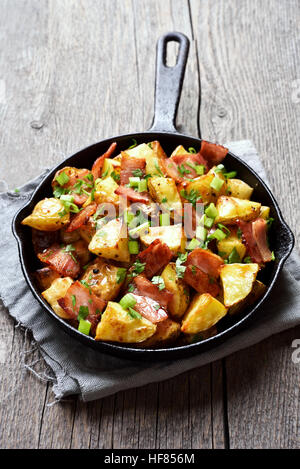 Bratkartoffeln mit Speck und grüne Zwiebel in der Pfanne Stockfoto