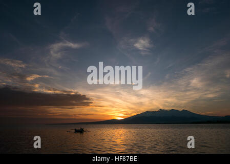 Sonnenuntergang mit Fisher Mann in einem Boot im Meer in der Nähe von Gili Air indonesischen Insel Angeln Stockfoto