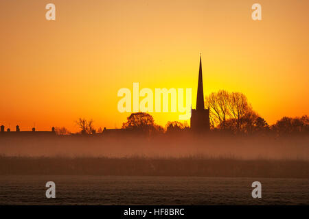 Sonnenaufgang über dem Kirchturm von Repton, Derbyshire, Großbritannien. Wetter in Großbritannien. Dezember 2016. -3.5C kalter, frostiger und nebliger Sonnenaufgang. Das Dorf Repton, Heimat der berühmten Schule und in der Nähe des Flusses Trent, erwacht in diesem Winter zum kältesten Morgen. Quelle: MediaWorldImages/AlamyLiveNews. Stockfoto