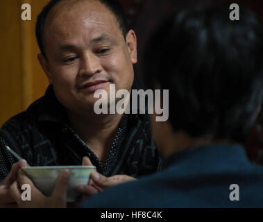 (161228)--HENGSHUI, 28. Dezember 2016 (Xinhua)--Wang Mingchen (L) bringt eine Mahlzeit zu Li Jianguo am Haus von Li Jianguo in Taocheng Bezirk in Hengshui Stadt, Nordchinas Provinz Hebei, 28. Dezember 2016. Wang Mingchens linke Bein amputiert wurde wegen eines Autounfalls im Jahr 2000. Unterdessen litt Li Jianguo, Wang Mingchens Nachbar und ehemaliger Arbeitskollege, hohe Querschnittslähmung verursacht durch einen Unfall im Jahr 2001. Als er die meisten pflegebedürftig war, ließ ihn Li es Eltern starben in Folge und seine Frau mit ihrem Kind. Gefühl für Li, Wang versprach, ihn sein ganzes Leben lang kümmern, und er hat zu seinem geklebt Stockfoto