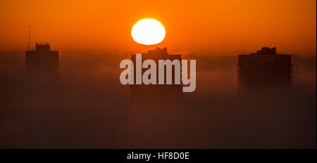 London, UK. 28. Dezember 2016. UK-Wetter: Dramatische Abendsonne durch dichten Nebelwolken über Tustin Anwesen in Peckham © Guy Corbishley/Alamy Live News Stockfoto